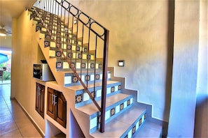 Stunning staircase with decorative patterned steps and a simple metal handrail.
