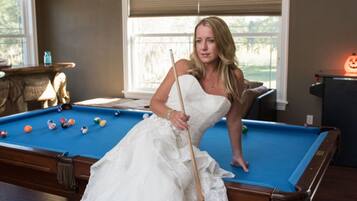 Enjoy a game of pool in this classic room with a pool table and large window.