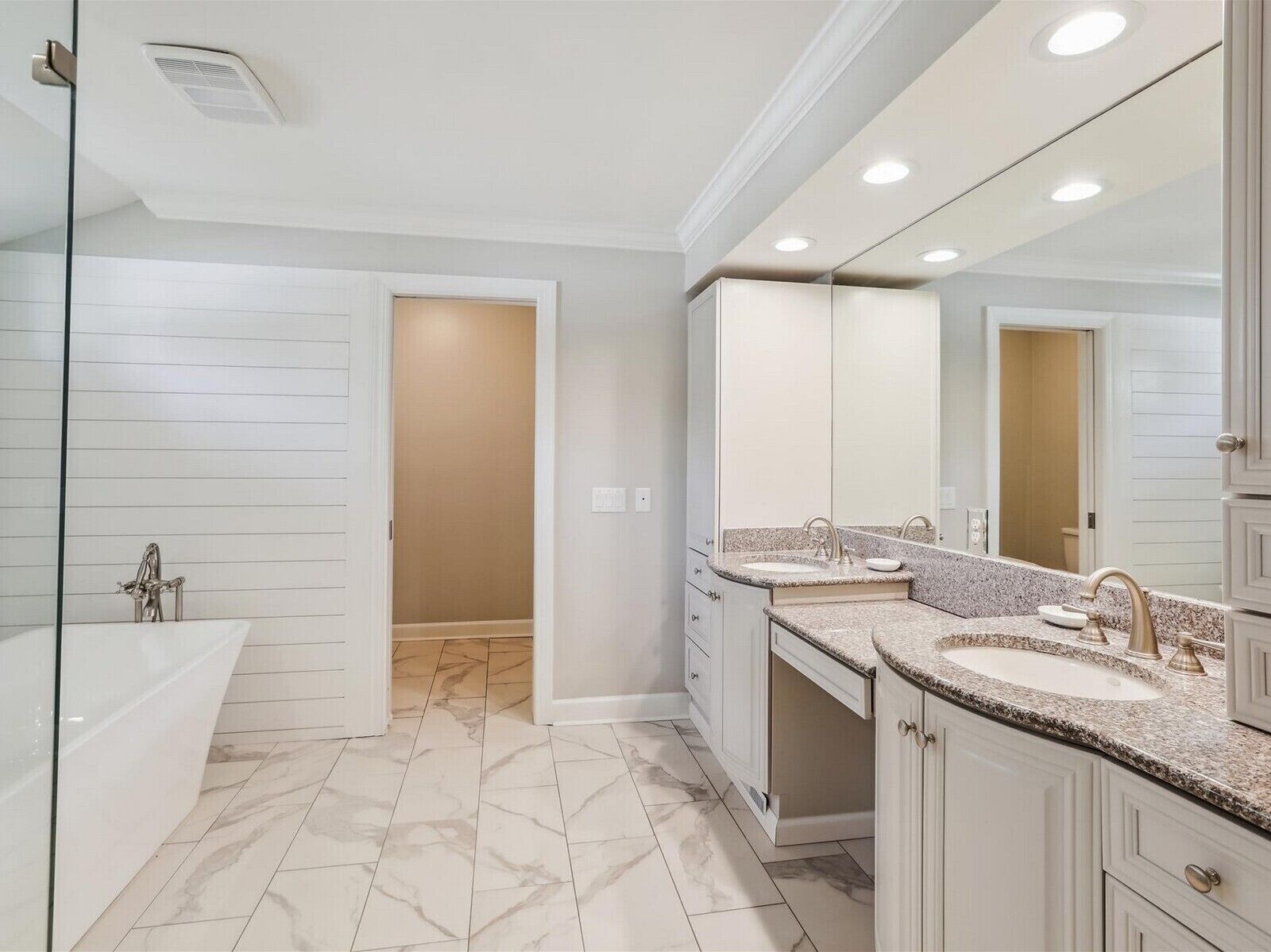 Une salle de bain moderne avec un meuble-lavabo à deux vasques, un grand miroir et une douche à l’italienne.