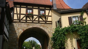 Un bâtiment traditionnel à colombages, doté d’une arche en pierre et d’un toit recouvert de tuiles rouges.