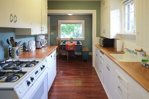 Enjoy cooking in this well-equipped kitchen with a central island, stove, microwave, and sink.