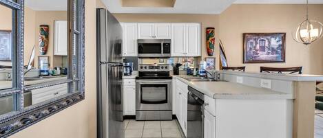 Una cocina moderna con armarios blancos, electrodomésticos de acero inoxidable y una isla grande.
