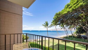 A balcony with a clear view of the ocean and palm trees. - Maui Condo Ocean and Park Views Kealia Unit 205 Tranquil Beach Front Resort (Kihei)
