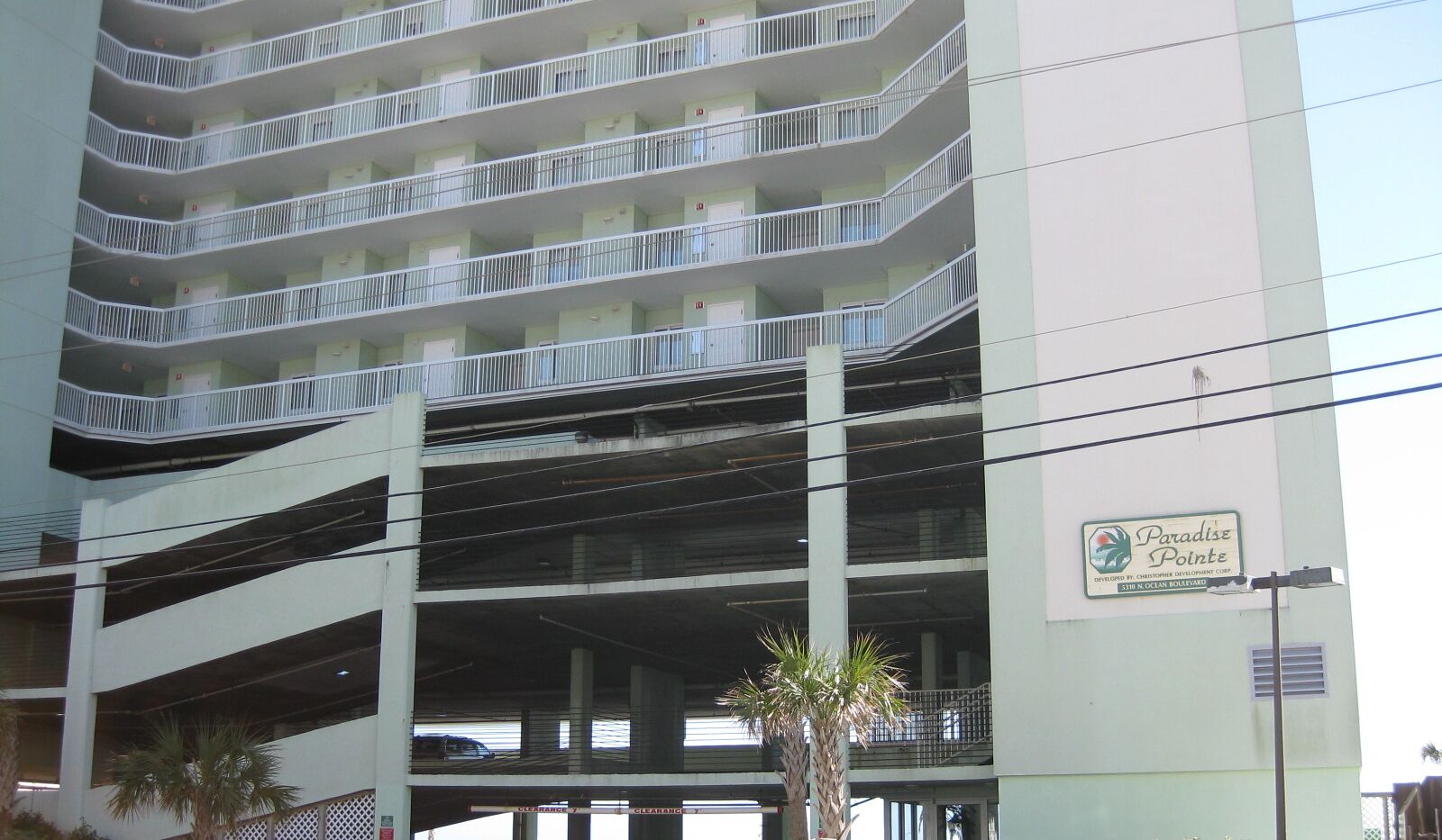 Un parking à plusieurs étages avec une enseigne indiquant « Paradise Pointe ».