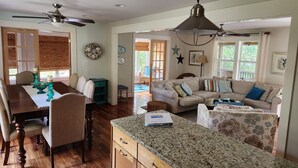 A spacious living area with a dining table, a sofa, and a kitchen counter.