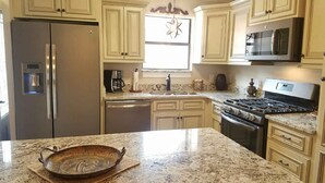 A kitchen with a stainless steel refrigerator, a coffee maker, a microwave, and a stove. - 153 Grand Island Blvd ~ Total Reno~Custom Kitchen~Granite~WiFi (Panama City Beach)