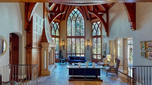 Un intérieur spacieux avec de hauts plafonds, des poutres en bois et de grandes fenêtres.