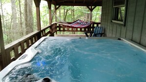 A hot tub with a wooden deck and a hammock. - 2BR +loft  Cottage in the mountains Va Creeper Trail, HOT TUB, ATV rentals,  (Mountain City)