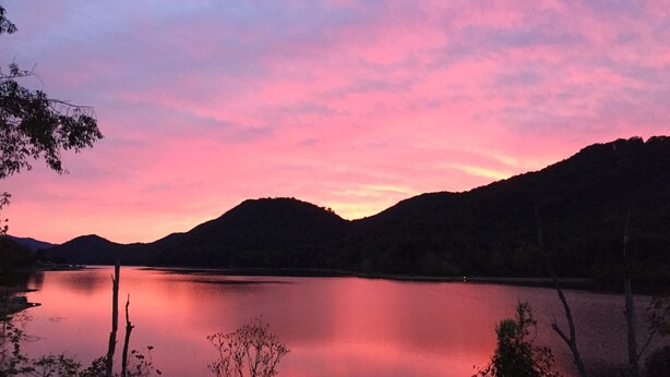 A calm lake at sunset with mountains in the background. - 2BR +loft  Cottage in the mountains Va Creeper Trail, HOT TUB, ATV rentals,  (Mountain City)