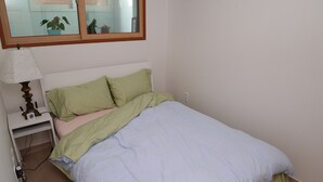 Ein Schlafzimmer mit Bett, Nachttisch, Lampe und Spiegel.
