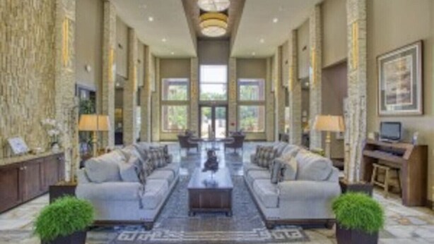 A spacious lobby with a central seating area, large windows, and a stone accent wall. - Beautiful Large 2 Bedroom / 2 Bath Condo in The Wo (The Woodlands)