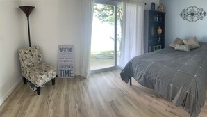A bedroom with a bed, a chair, a bookshelf, and a sign. - 4 Bed and 3 Bath  - Lakefront with private dock (Camdenton)