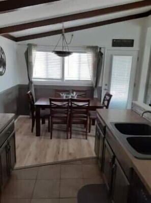 Enjoy meals in this cozy kitchen with a dining table and chairs, a sink, and a stove.