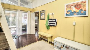 A room with a wooden floor, a bench, a wall-mounted bag rack, and a framed picture. - Come to the cottage! 3BR2BA - Bethany West. Pool, pickleball, tennis, gym. Pets! (Bethany Beach)