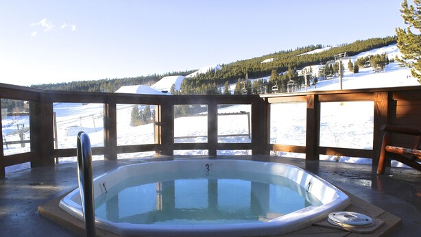 A hot tub on a wooden deck with a snowy mountain view. - Breckenridge Peak 8 True Ski-In Ski-Out At Over 10,000 Ft. (Breckenridge)