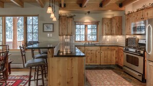 Une cuisine spacieuse avec des meubles en bois, un îlot central et une grande cuisinière.
