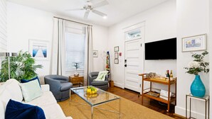 A modern living room with a sofa, armchairs, a coffee table, and a TV. - A2 at Saint Philip Square, One Block to King, Stylish Southern Escape (Charleston)