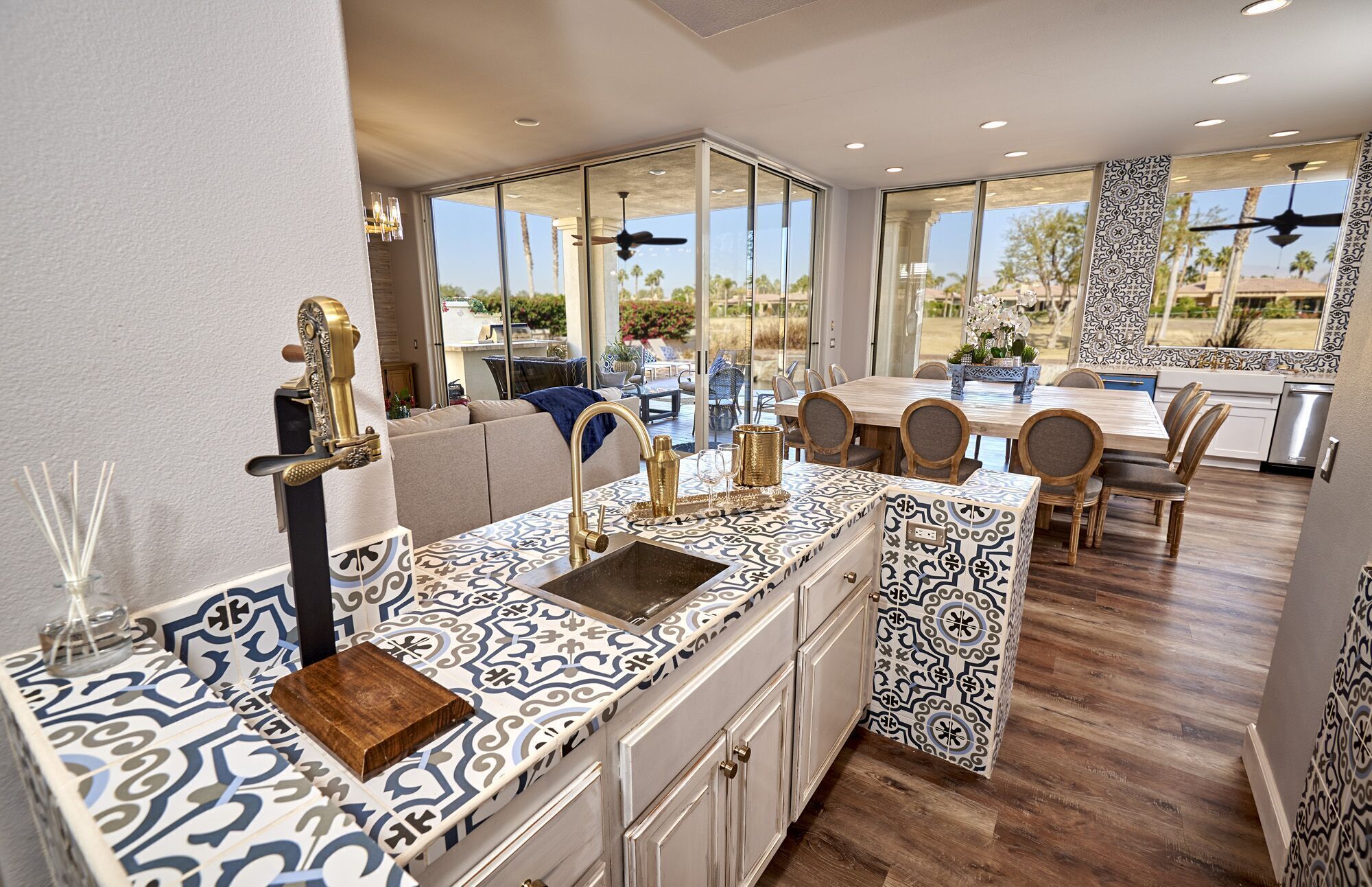 Una cocina moderna con un salpicadero de diseño, una isla integrada con un lavamanos y un comedor con mesa y sillas de madera.