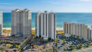 Un grand hôtel à plusieurs étages, doté d’un parking et offrant une vue sur l’océan.