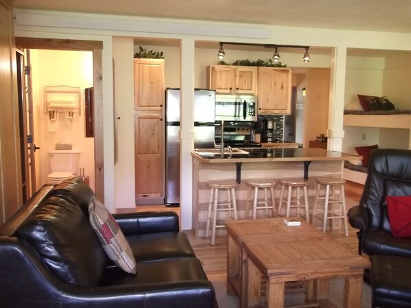 A compact living space with a kitchenette, a dining area with stools, and a seating area with a sofa and a table. - Fall is great in the Tetons Wildlife, Tram & Mountain Views, Creek, Free Bikes (Wilson)