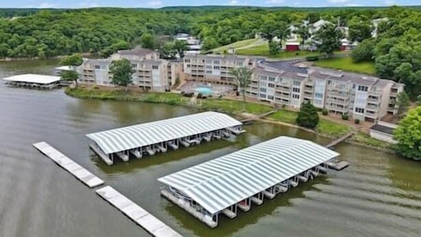 A lakeside hotel with multiple docked boats, a central courtyard, and surrounding greenery.