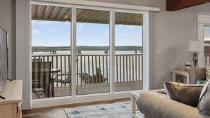 A room with a large sliding glass door leading to a balcony with a view of the landscape.