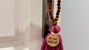 Uma porta com maçaneta e chaveiro de madeira com a inscrição 'não perturbe'.