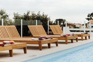 Una piscina al aire libre, camas de piscina gratis, sombrillas