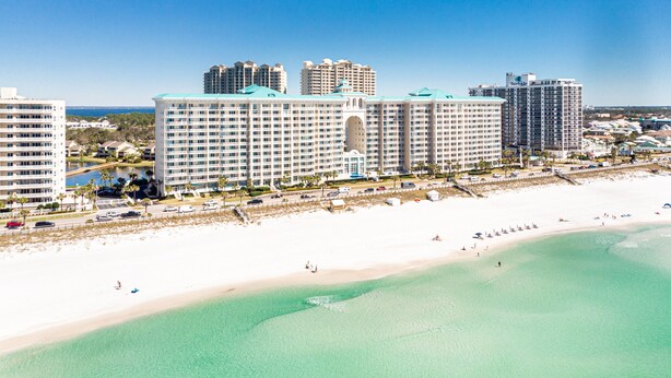 A beachfront hotel with multiple floors, a pool, and a beach view.