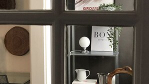A room with a dark wooden chair, a white pitcher, and a shelf with books and a small plant. - Bright & Stylish •  Heart of Old City •  Great Design (Berne)