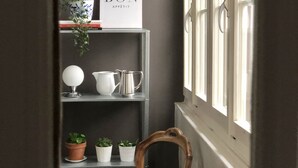 A view through a window into a room with a bookshelf, a chair, and a sign reading "BON APPETIT". - Bright & Stylish •  Heart of Old City •  Great Design (Berne)