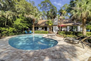 A swimming pool with lounge chairs and a patio area surrounded by trees and a house. - 67 Mooring Buoy- Pet Friendly & and only a Quick 3-Minute Walk to the Beach (Hilton Head Island)