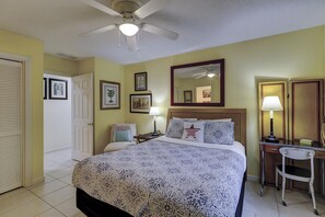 A hotel room with a bed, a desk, a chair, a ceiling fan, and a mirror. - 67 Mooring Buoy- Pet Friendly & and only a Quick 3-Minute Walk to the Beach (Hilton Head Island)