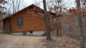 Une cabane en bois avec une véranda, une fenêtre et une porte.