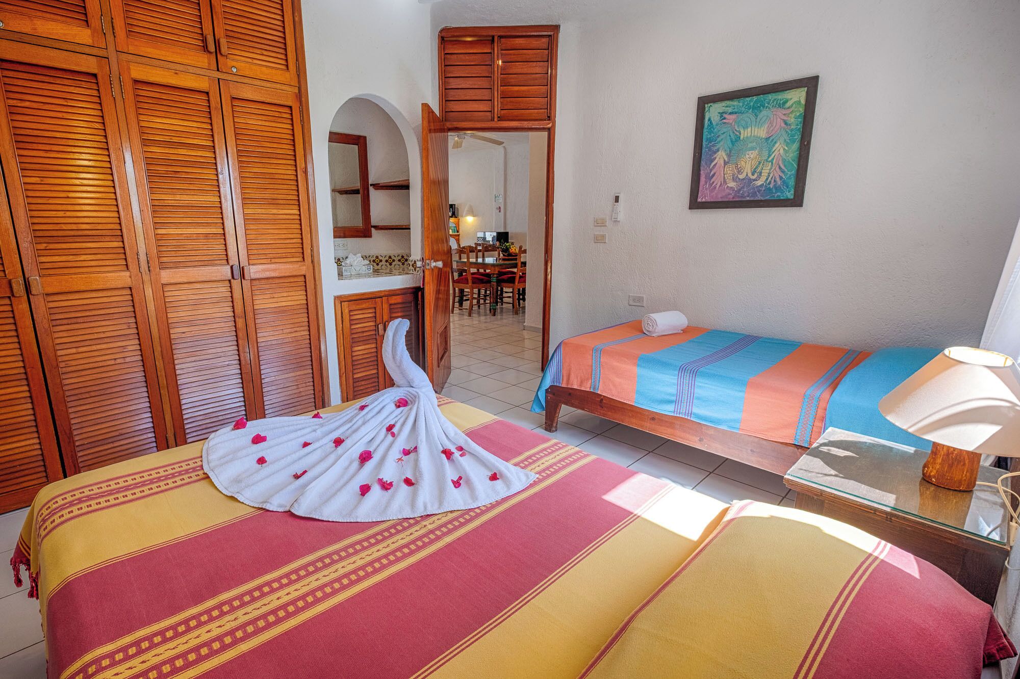 Une chambre d’hôtel avec un lit, une chaise, une table et un tableau au mur.