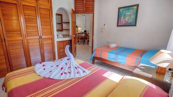 Une chambre d’hôtel avec un lit, une chaise, une table et un tableau au mur.