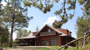 A lodge with a large garage, a covered porch, and a prominent chimney. - Large home on 5 acres, 5 bedrooms, 3 bathrooms and sleeps up to 14 people (Fraser)