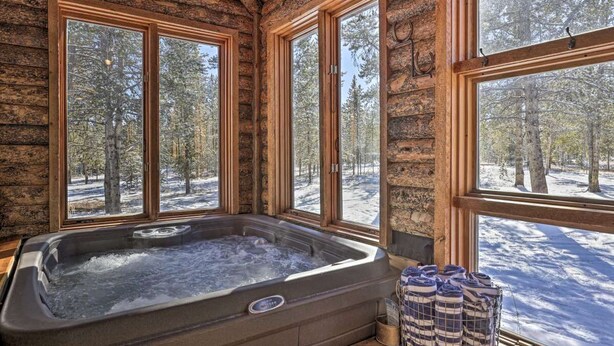 A log cabin with a hot tub and large windows offering a snowy forest view. - Large home on 5 acres, 5 bedrooms, 3 bathrooms and sleeps up to 14 people (Fraser)