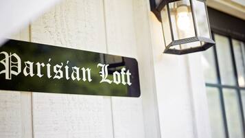 Een straatnaambordje met de tekst 'Parisian Loft' bevestigd aan een gebouw.