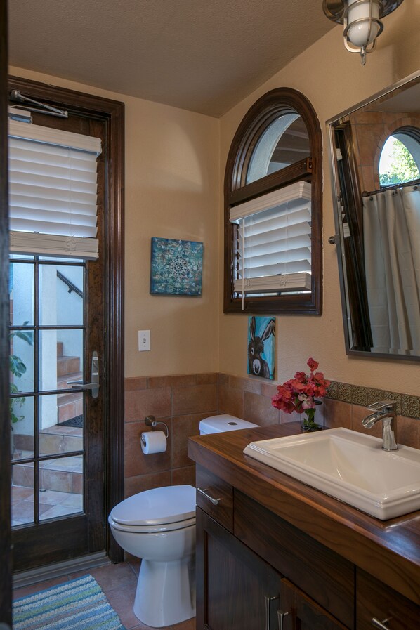 A bathroom with a toilet, sink, and mirror.