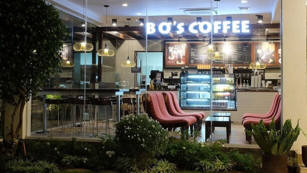 A coffee shop with a glass storefront, interior seating, and a menu board. - Brand New Condo (Fully Furnished) with Fast WIFI & Cable TV (Unknown)
