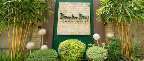 Welcome to Bamboo Bay Community, where lush greenery surrounds the entrance.