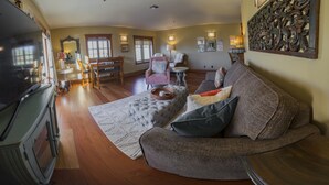 A living room with a sofa, armchairs, a coffee table, and a TV. - FisherBros flats 203 (Astoria)