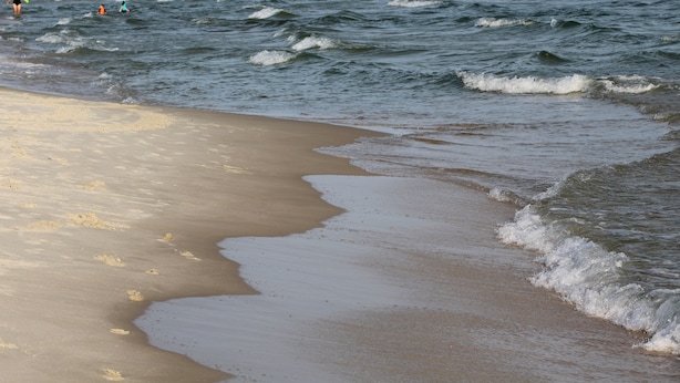 Ein Strand mit sanft anschwellenden Wellen.