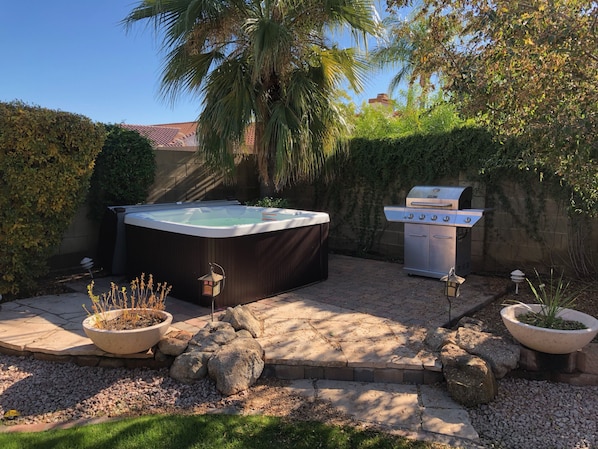 A backyard with a hot tub, a grill, and potted plants. - Luxury Home w/ NEW back yard and Heated Pool (Scottsdale)