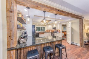 Una cocina amplia con una isla grande, detalles de madera e iluminación moderna.