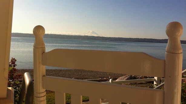 A view from a balcony overlooking a body of water with a distant mountain. - Point Robinson Lighthouse - Keeper's Quarters B (Vashon Island)