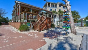 A wooden building with a balcony and a signboard with multiple directions. - Walk to beach, indoor/outdoor pools, washer/dryer (Hilton Head Island)