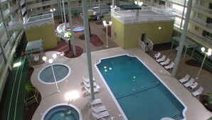 An indoor swimming pool with multiple lanes, lounge chairs, and a sun deck area. - Walk to beach, indoor/outdoor pools, washer/dryer (Hilton Head Island)