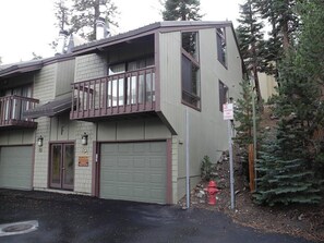 A two-story building with a balcony, a garage, and a fire hydrant.